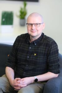 Alex Walker sat on a sofa in the Clicky office